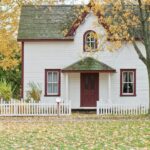 Picturesque traditional house with autumn foliage and a white picket fence in London, Ontario.