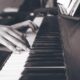 person playing upright piano in sephia photography