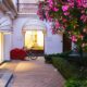 Serene evening view of a boutique hotel entrance in Sochi, adorned with vibrant flowers and warm lighting.