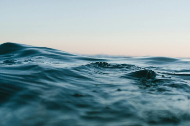 Tranquil ocean waves under a soft sunset sky, perfect for backgrounds.