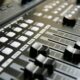 Detailed view of audio mixer sliders and buttons for sound engineering and music production.