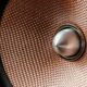 Detailed view of a metallic speaker cone with textured pattern and modern design.