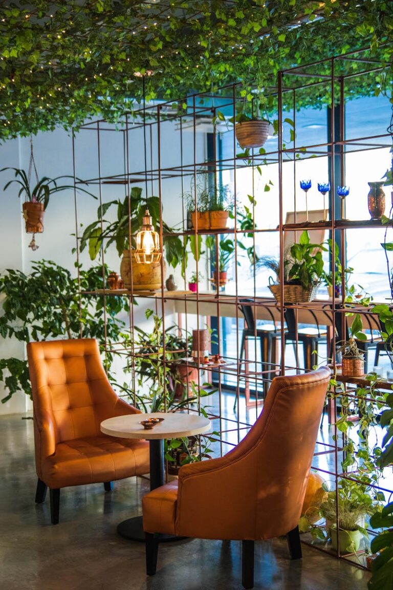 Inviting café corner with lush plants and cozy seating, perfect for relaxation.